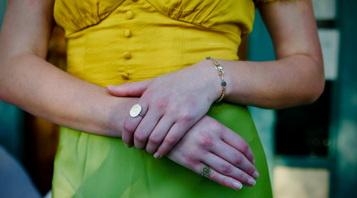Woman wearing a Victorian-inspired top with handcrafted rings and bracelet by Narrow-Gauge Designs.