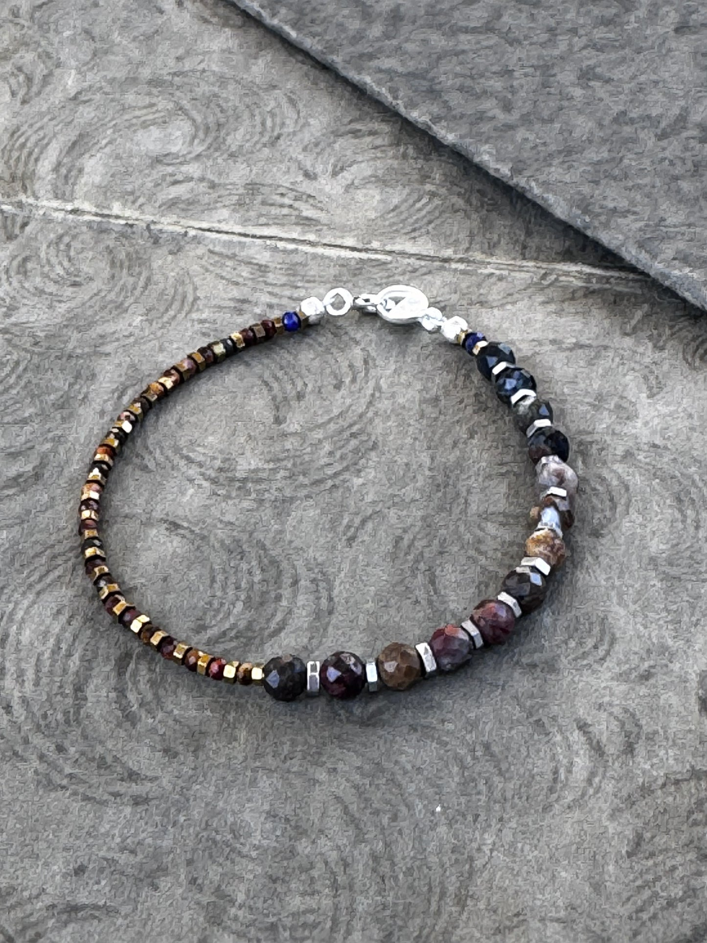 Bracelet with Pietersite and Red Tiger Eye beads on a gray surface