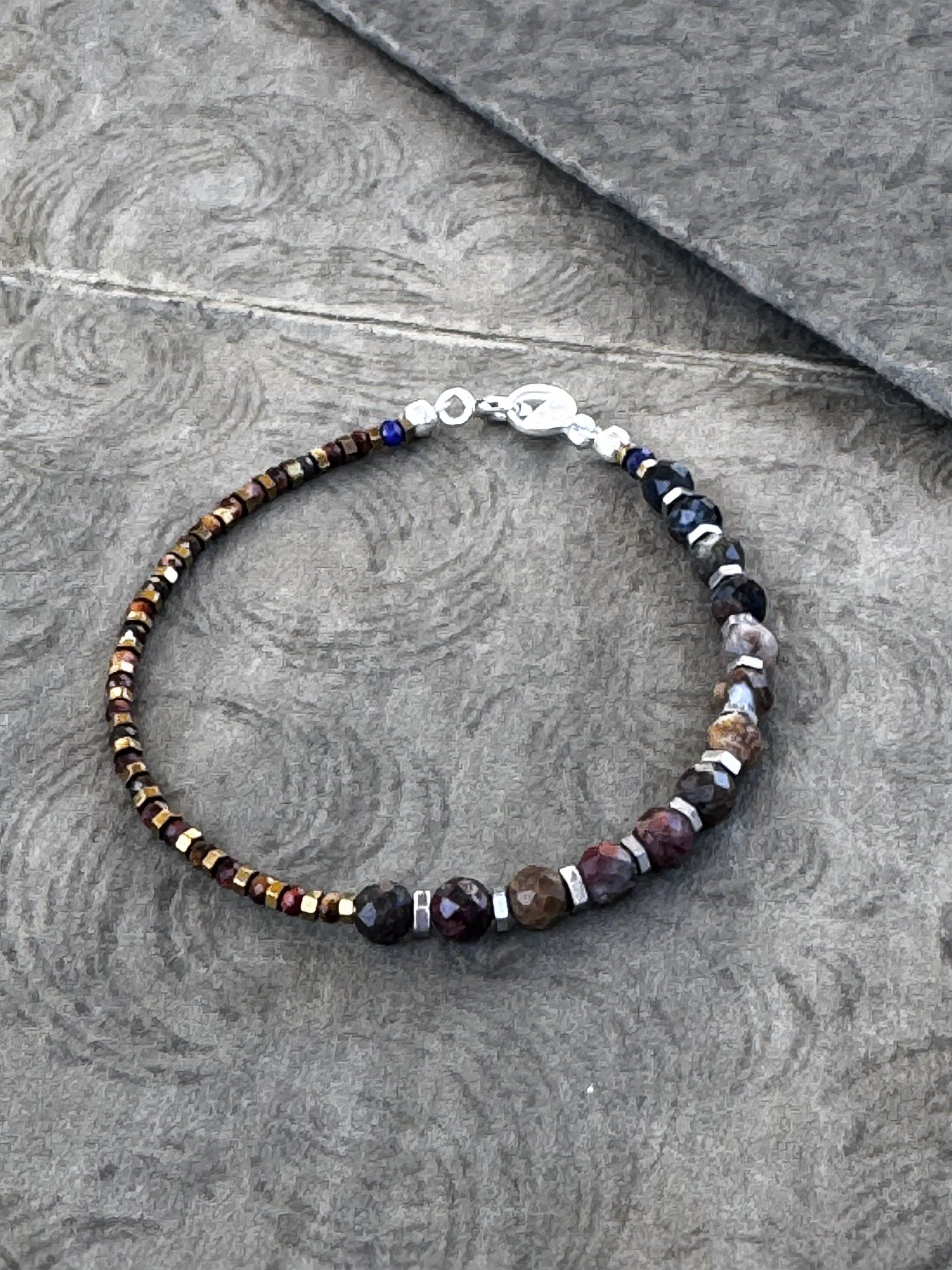 Bracelet with Pietersite and Red Tiger Eye beads on a gray surface