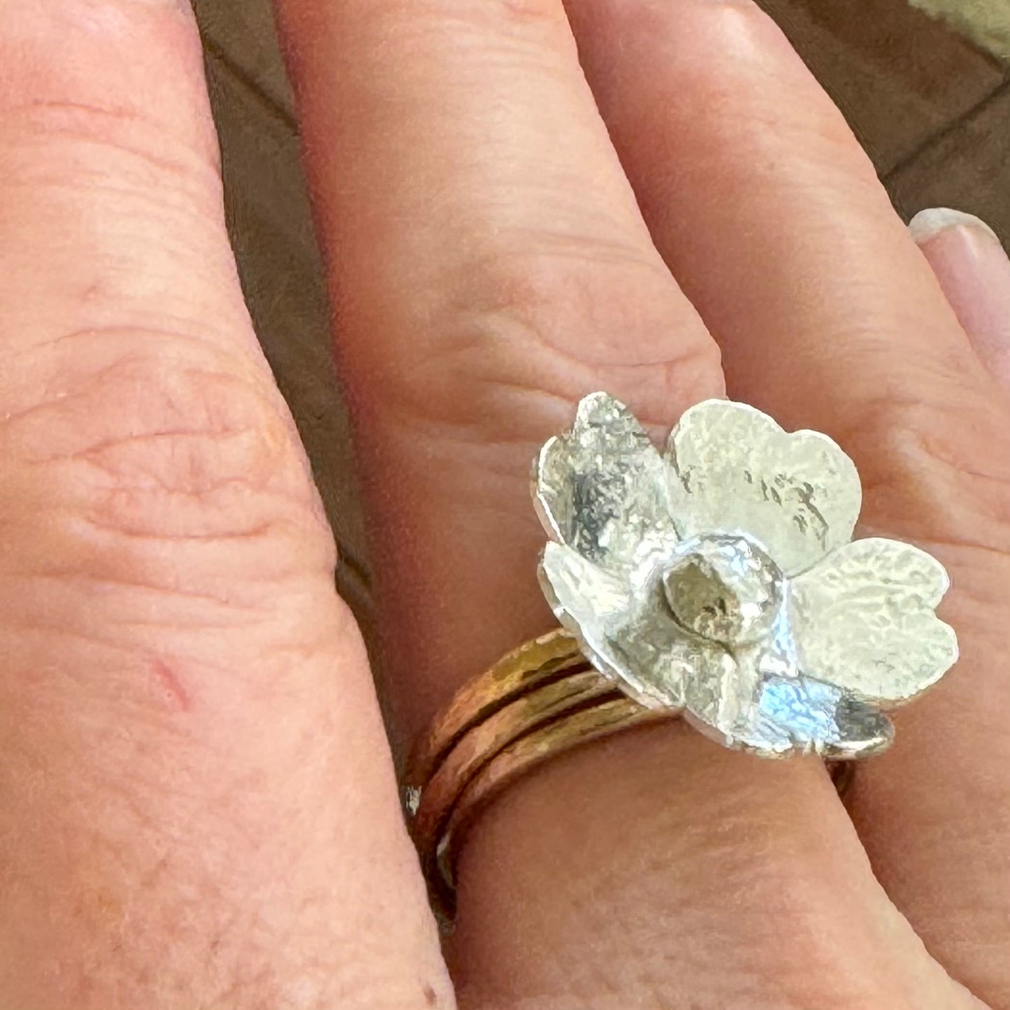 Rustic floral ring worn on hand, sterling silver and brass design from The Floret Collection, artisan-crafted in California