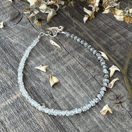 Angels Camp bracelet with Moonstone and Hematite resting on aged wood with faded rose buds, showcasing rustic, vintage charm